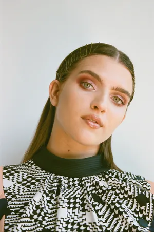 Mae Muller Striking A Pose During A Photoshoot Wallpaper