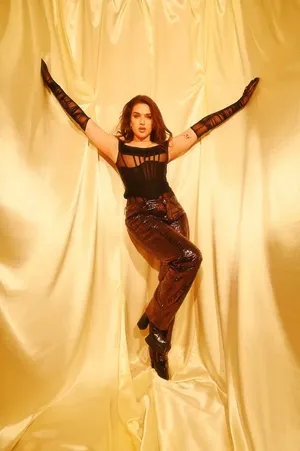 Mae Muller Striking A Pose On A Striking Pink Background Wallpaper