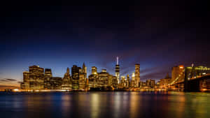 Magnificent View Of The New York City Skyline At Night Wallpaper