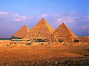 Majestic Giza Pyramids Bathed In Golden Sunset Glow Wallpaper