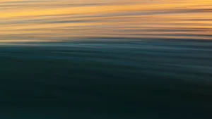 Majestic Golden Sunrise Over The Serene Blue Ocean Wallpaper