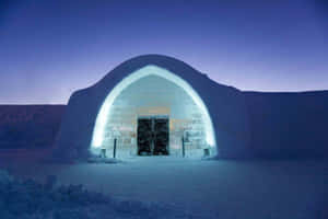 Majestic Ice Hotel Illuminated At Night Wallpaper