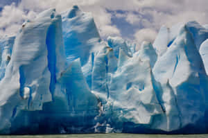 Majestic Iceberg Floating In Pristine Blue Waters Wallpaper