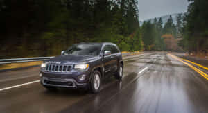 Majestic Jeep Grand Cherokee Cruising On A Scenic Route Wallpaper