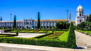 Majestic Mosteiro Dos Jeronimos On A Bright Sunny Day Wallpaper