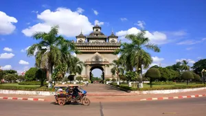 Majestic Patuxai Monument With Passing Vehicle In Vientiane, Laos Wallpaper