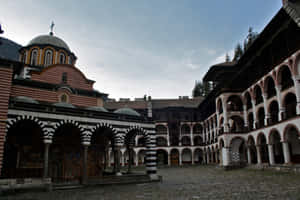 Majestic Rila Monastery Against The Backdrop Of Beautiful Mountain Landscapes Wallpaper