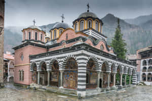 Majestic Rila Monastery Under A Serene Sky Wallpaper