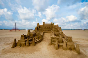 Majestic Sandcastle On A Sunlit Beach Wallpaper