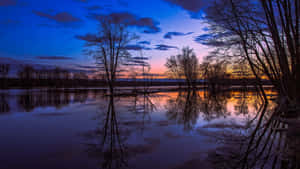 Majestic Sunset Reflection Over Calm Waters Wallpaper