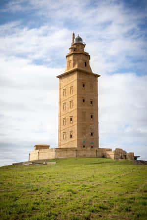 Majestic Tower Of Hercules Piercing The Blue Sky Wallpaper