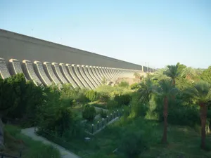 Majestic View Of Aswan High Dam With Green Garden Wallpaper