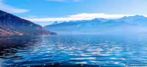 Majestic View Of Thun City With Lake And Snow-capped Mountains Wallpaper