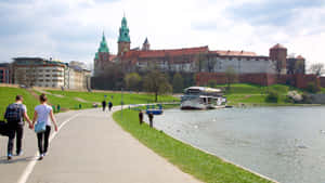 Majestic View Of Wawel Castle By The River In Kraków, Poland Wallpaper