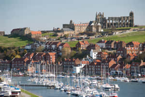 Majestic Whitby Lighthouse Against A Beautiful Sunset Wallpaper