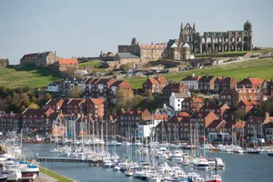 Majestic Whitby Lighthouse Against A Beautiful Sunset Wallpaper