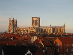 Majestic York Minster Cathedral Surrounded By A Sea Of Buildings Wallpaper