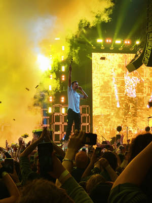 Male Performer On Neon Yellow Stage Wallpaper