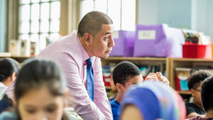 Male Teacher Discussing Lesson To Students Wallpaper