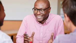 Male Teacher Happy Smile Inspiring Students Wallpaper