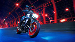 Man Driving A Black Yamaha Mt 15 Wallpaper