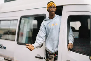 Man Exiting Van In The Bustling Streets Of Sierra Leone Wallpaper