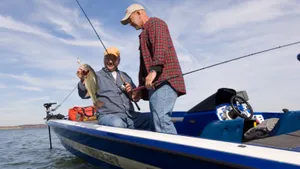 Man Expertly Casting His Fishing Rod By The Lake Wallpaper