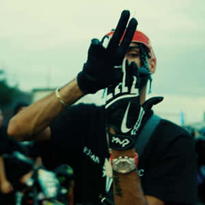 Man Gesturing Peace Sign Outdoors Wallpaper