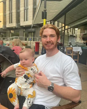 Man Holding Baby Outdoors Wallpaper