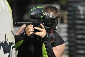 Man In Green Elbow Pads Shooting Paintball Wallpaper