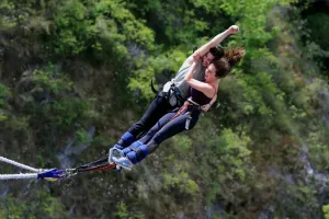 Man Leaps Between Mountain Peaks Wallpaper