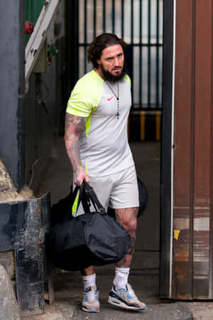 Man Leaving Building With Bag Wallpaper