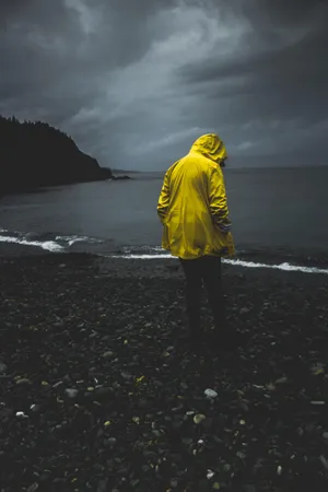 Man On Rocky Seashore Alone Phone Wallpaper