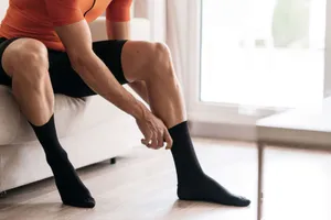 Man Putting On Black Socks Wallpaper