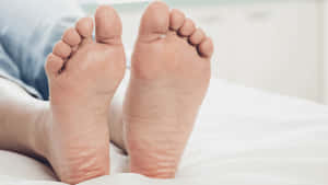 Man Relaxing On Bed - Closeup Of Male Feet Wallpaper