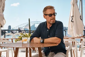 Man Relaxingat Harbourfront Cafe Wallpaper