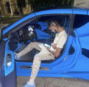 Man Relaxingin Blue Sports Car Wallpaper