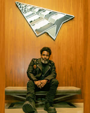 Man Seated Below Arrow Sign Wallpaper