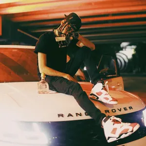 Man Seatedon Range Rover Hood Night Wallpaper