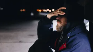 Man Sitting Alone By Bridge Railing Wallpaper