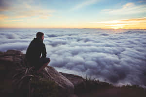 Man Sitting On A Rock Waiting For The Sunset Wallpaper