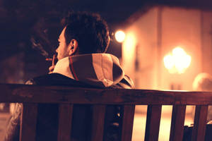 Man Smoking While Sitting Alone Wallpaper