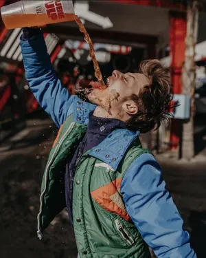 Man Spilling Drink Outdoors Wallpaper