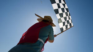 Man Waving A Checkered Flag Wallpaper