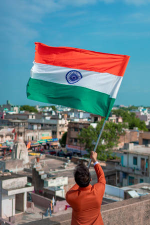 Man Waving Tiranga On Balcony Wallpaper