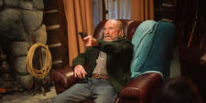 Man With Gun Seatedin Armchair Wallpaper