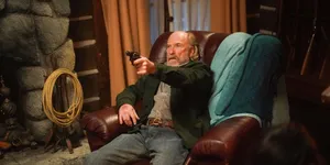 Man With Gun Seatedin Armchair Wallpaper