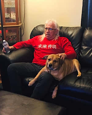 Manand Dog Relaxingon Couch Wallpaper