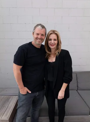 Manand Woman Smiling Against White Brick Wall Wallpaper