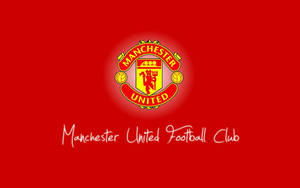 Manchester United Iconic Team Crest Passionately Illustrated On A Vibrant Red Background. Wallpaper